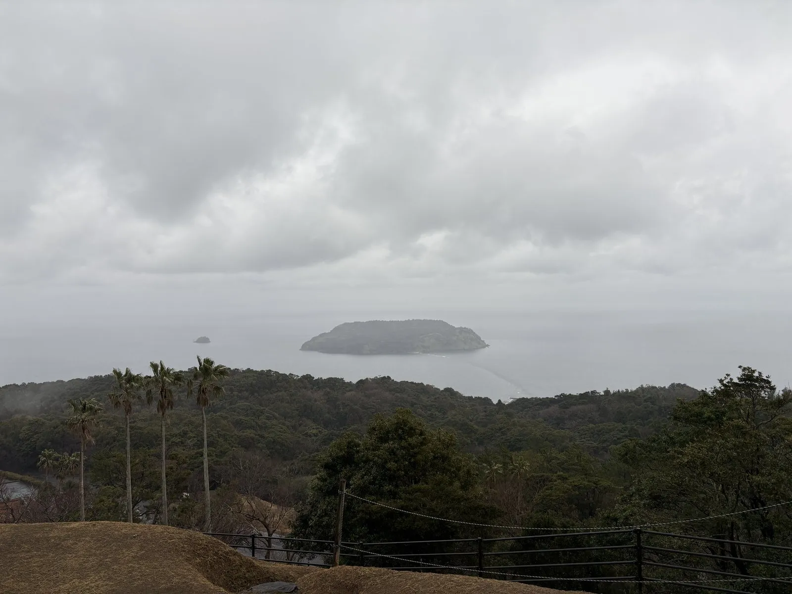雨の魚見岳展望台から見た指宿市街と、海に浮かぶ知林ヶ島
