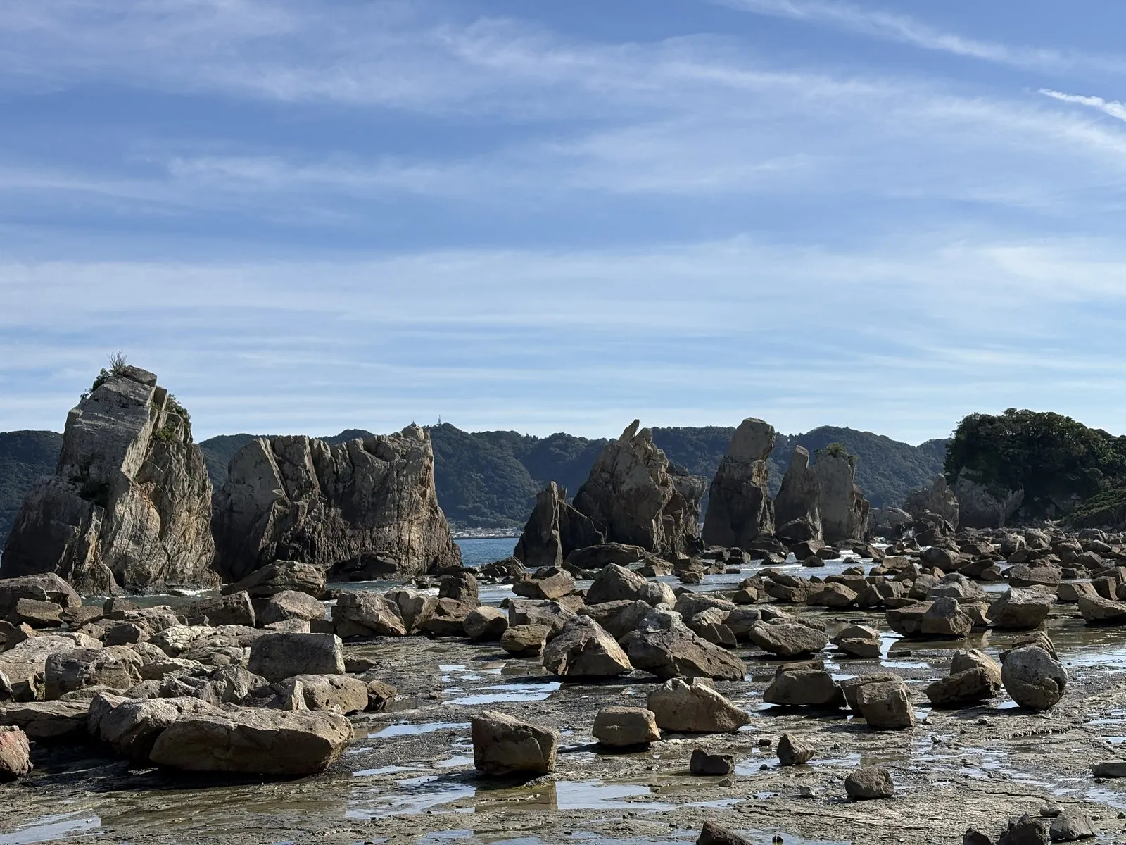 干潮の橋杭岩。手前の磯に無数の岩が転がり、奥に尖った岩の列が並ぶ