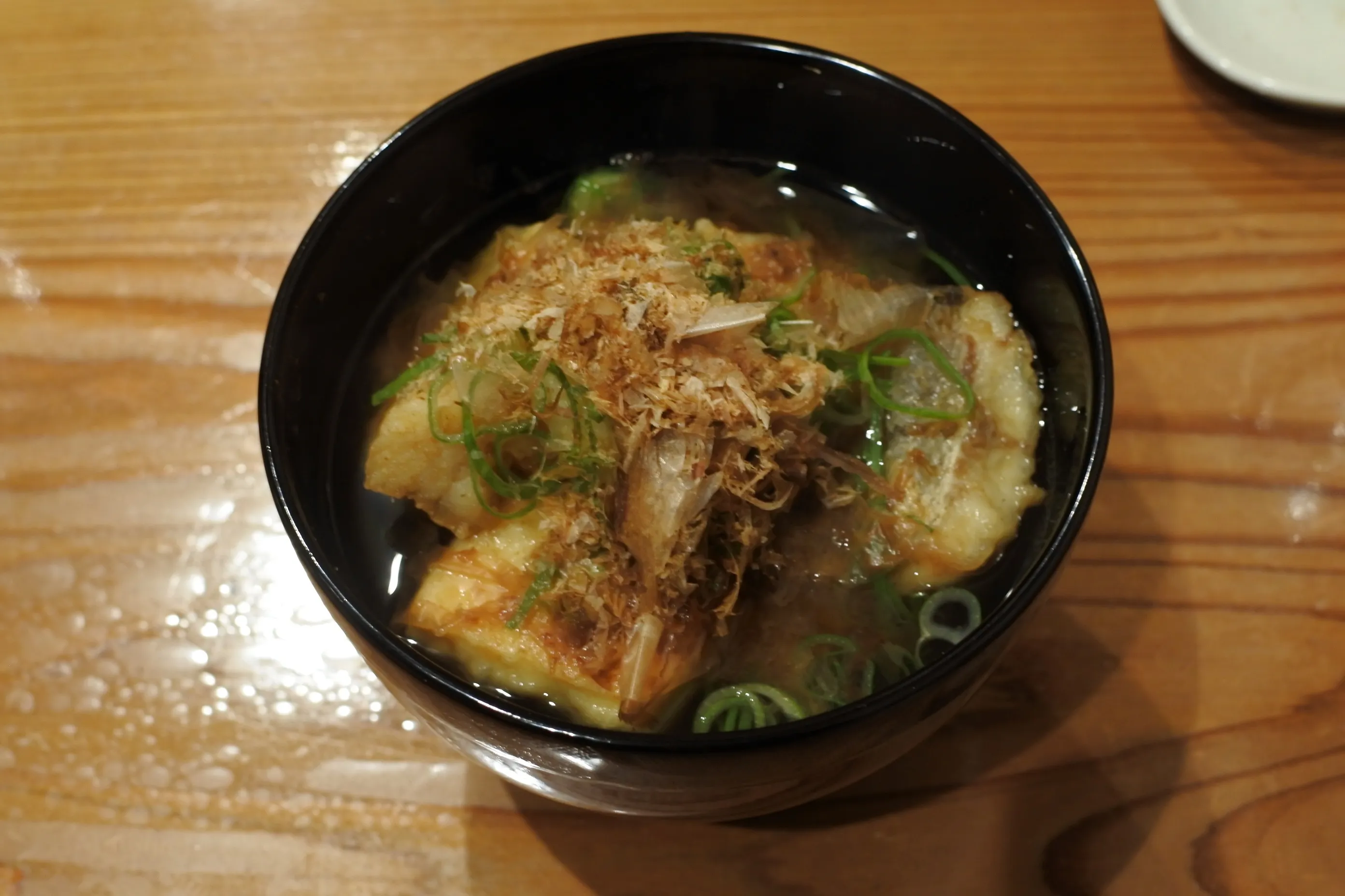 揚げ物に鰹節をかけた一品。湯気と香りが立ち上る、能登の地のもの