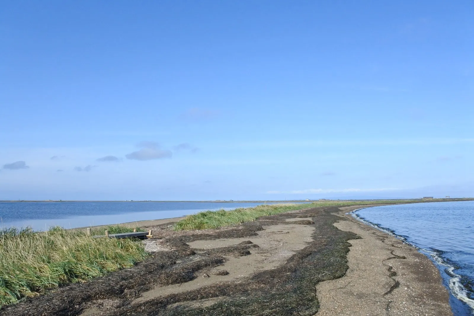 野付半島の砂嘴。細い砂の帯の左右を海と内湾に挟まれ、打ち上げられた海草が縞になっている。快晴